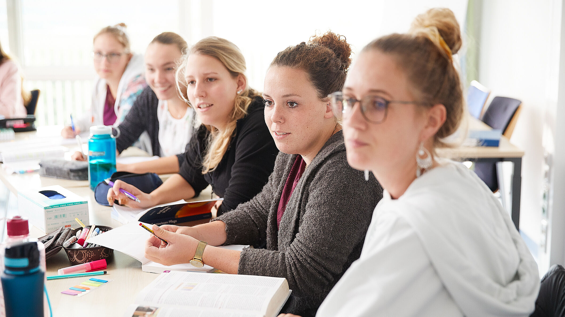 Fünf Schülerinnen sitzen im Klassenraum und schauen Richtung Tafel