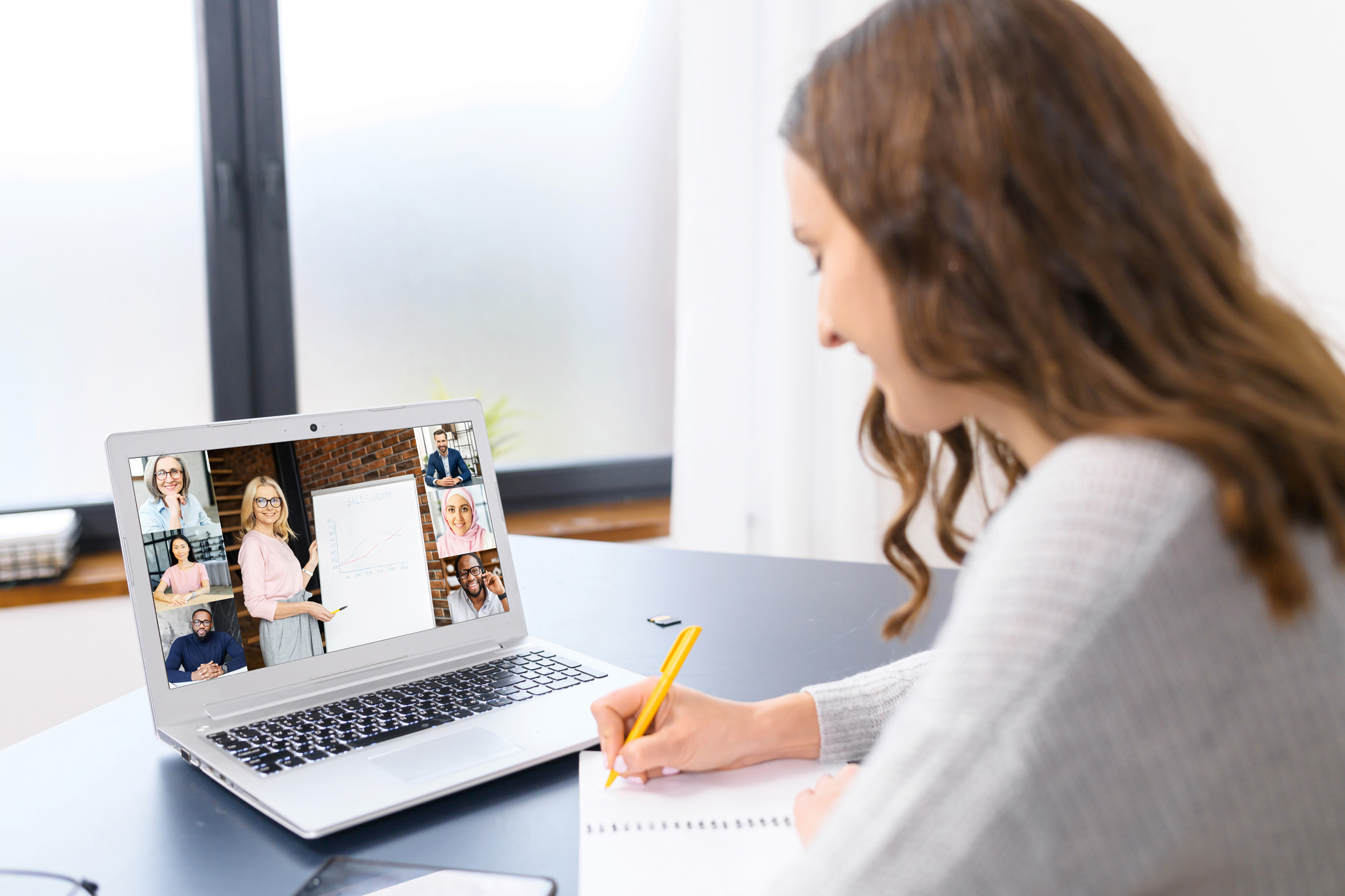 Frau nimmt am Laptop an einer Videokonferenz teil