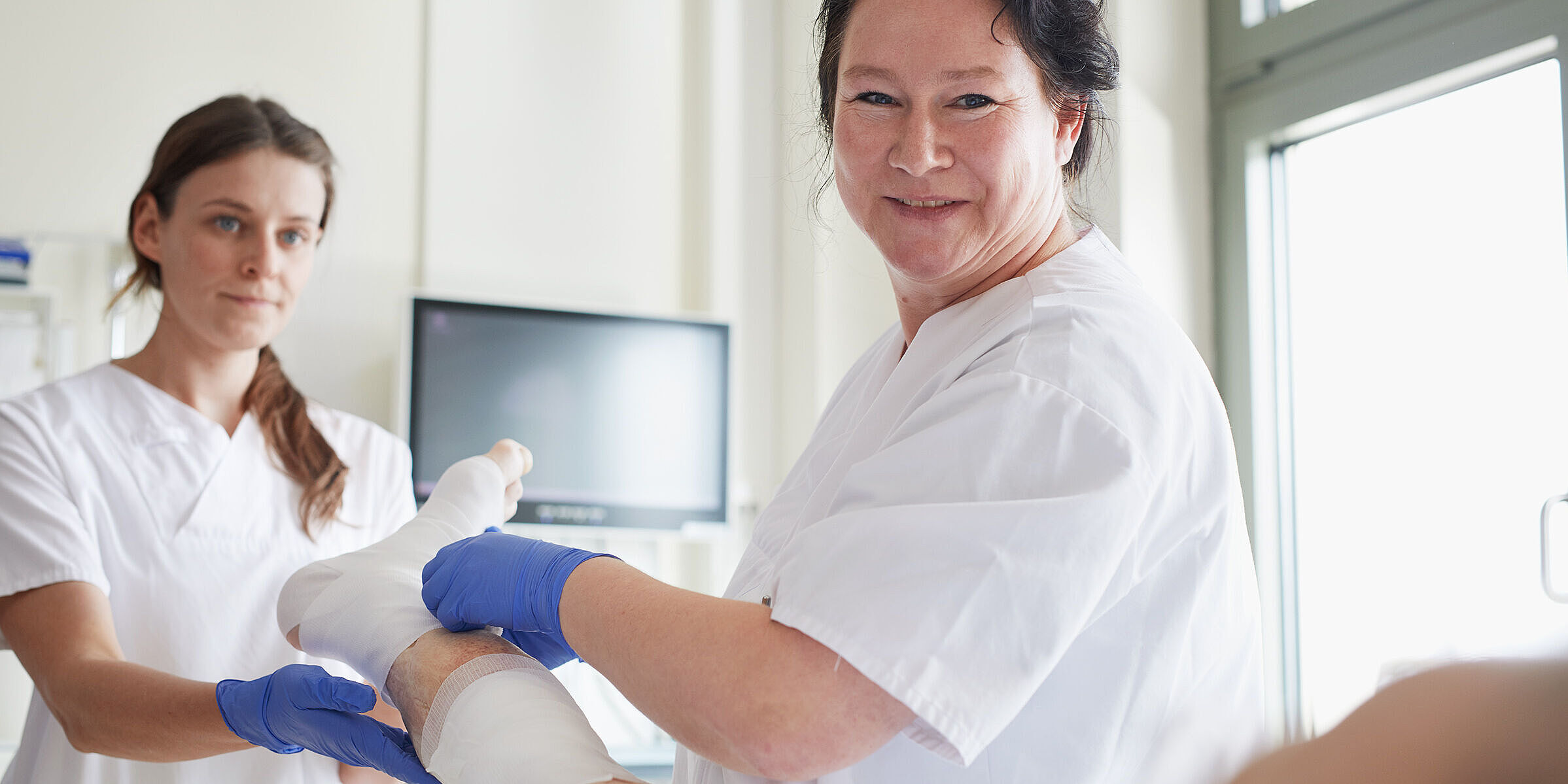 Zwei Pflegerinnen am Krankenbett