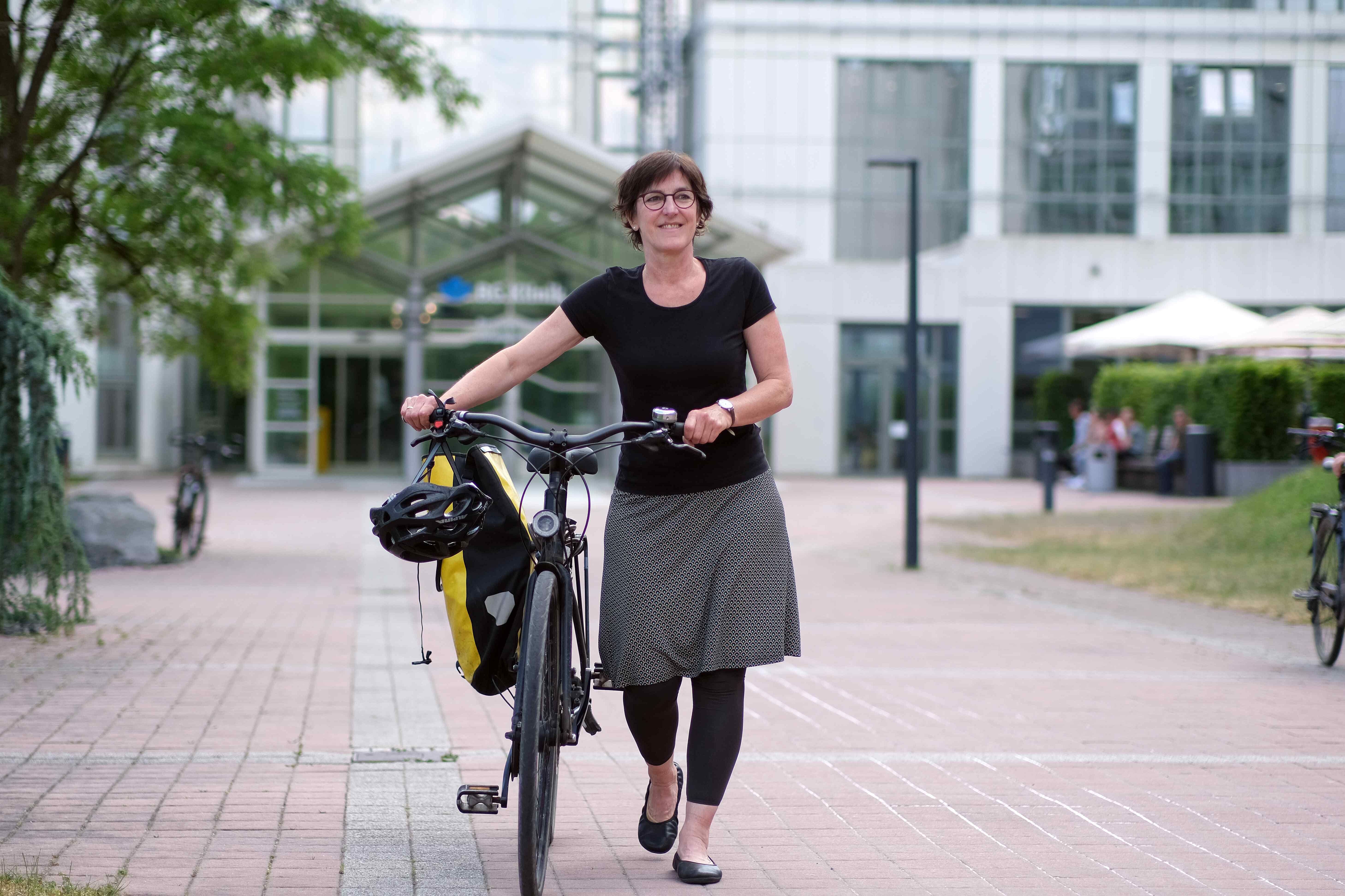 Pflegefachkraft mit dem Fahrrad auf den Weg in den Feierabend.