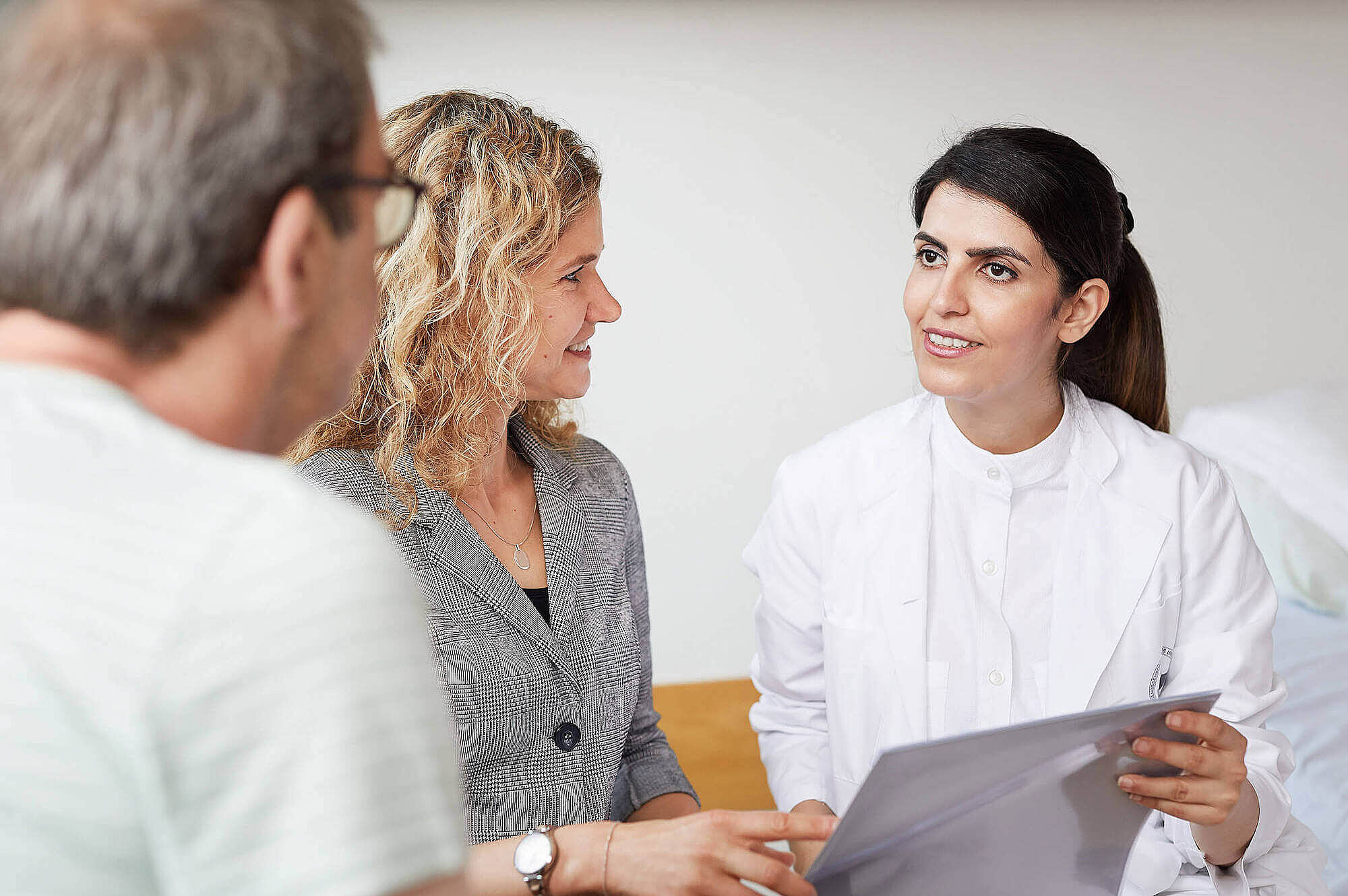 Eine Ärztin und eine Reha-Managerin beraten einen Patienten