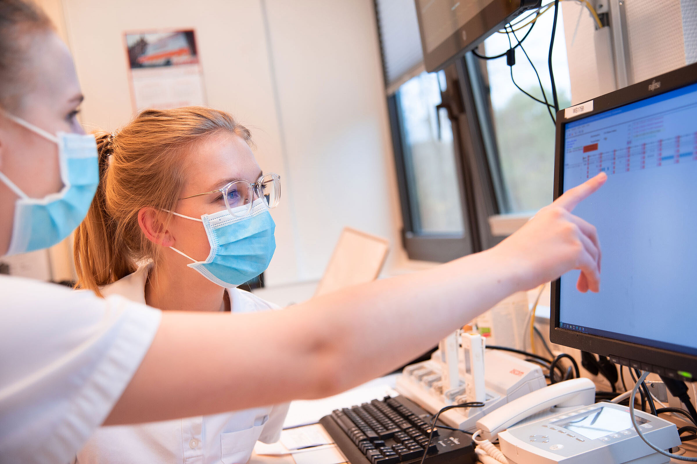 Marie Hellberg und Matilda Bachert prüfen ihre Dienstpläne im Zeiterfassungssystem des Klinikums. 